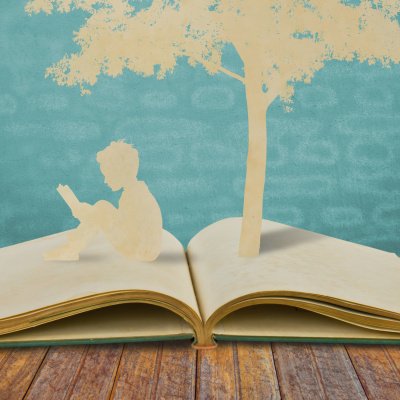 Paper cut of children read a book under tree on old book